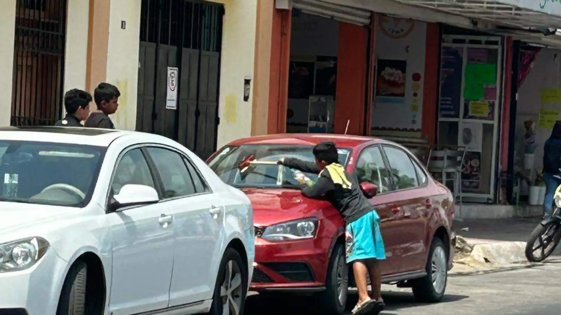 niño limpiando parabrisa